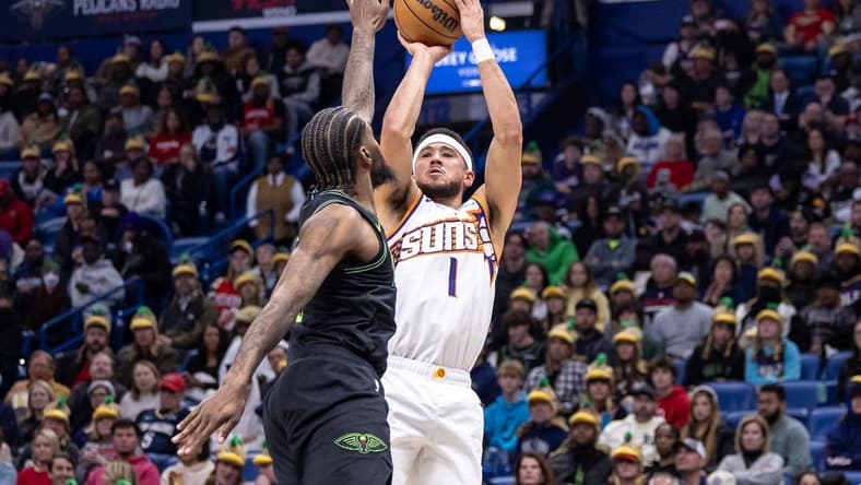 Jan 19, 2024; New Orleans, Louisiana, USA; Phoenix Suns guard Devin Booker (1) shoots against New Orleans Pelicans forward Naji Marshall (8) during the first half at Smoothie King Center. Mandatory Credit: Stephen Lew-USA TODAY Sports