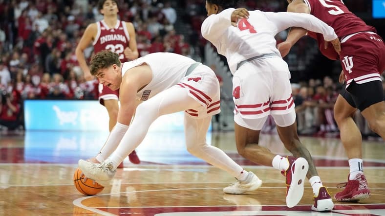 Jan 19, 2024; Madison, Wisconsin, USA; Wisconsin Badgers guard Max Klesmit (11) picks up a loose ball against Indiana Hoosiers forward Malik Reneau (5) and teammate Wisconsin Badgers guard Kamari McGee (4) during the first half at the Kohl Center. Mandatory Credit: Kayla Wolf-USA TODAY Sports