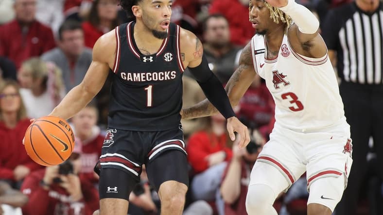 Jan 20, 2024; Fayetteville, Arkansas, USA; South Carolina Gamecocks guard Jacobi Wright (1) drives against Arkansas Razorbacks guard El Ellis (3) during the first half at Bud Walton Arena. Mandatory Credit: Nelson Chenault-USA TODAY Sports