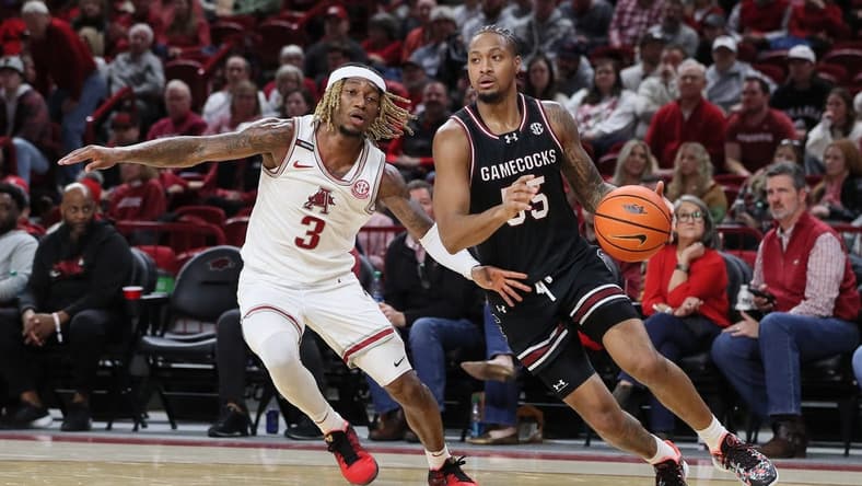 Jan 20, 2024; Fayetteville, Arkansas, USA; South Carolina Gamecocks guard Ta Lon Cooper (55) dribbles by Arkansas Razorbacks guard El Ellis (3) during the second half at Bud Walton Arena. Gamecocks won 77-64. Mandatory Credit: Nelson Chenault-USA TODAY Sports