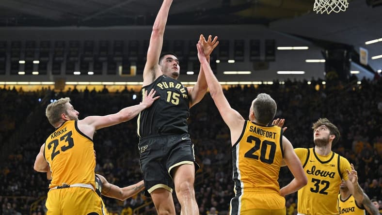 Jan 20, 2024; Iowa City, Iowa, USA; Purdue Boilermakers center Zach Edey (15) shoots the ball over Iowa Hawkeyes forward Ben Krikke (23) and forward Payton Sandfort (20) and forward Owen Freeman (32) during the second half at Carver-Hawkeye Arena. Mandatory Credit: Jeffrey Becker-USA TODAY Sports