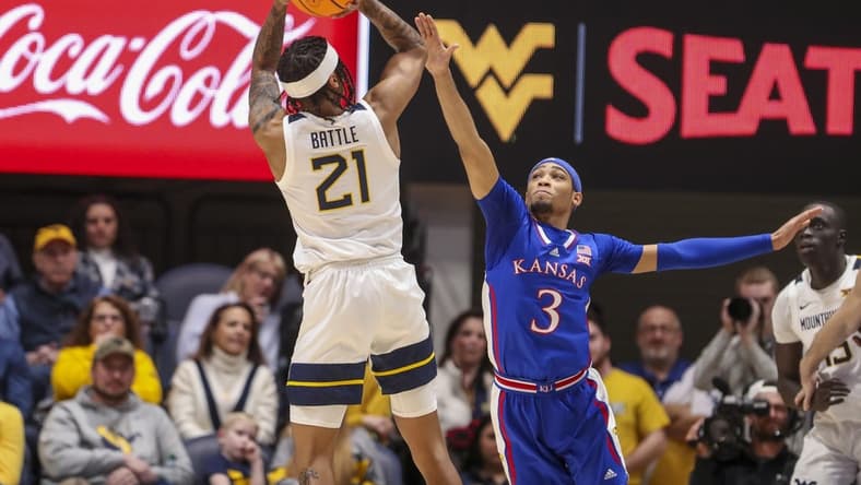 Jan 20, 2024; Morgantown, West Virginia, USA; West Virginia Mountaineers guard RaeQuan Battle (21) shoots over Kansas Jayhawks guard Dajuan Harris Jr. (3) during the first half at WVU Coliseum. Mandatory Credit: Ben Queen-USA TODAY Sports