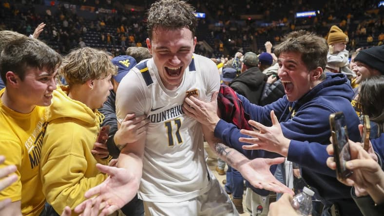 Jan 20, 2024; Morgantown, West Virginia, USA; West Virginia Mountaineers forward Quinn Slazinski (11) celebrates with students after defeating the Kansas Jayhawks at WVU Coliseum. Mandatory Credit: Ben Queen-USA TODAY Sports