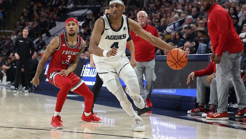 Jan 20, 2024; Logan, Utah, USA; Utah State Aggies guard Ian Martinez (4) drives past Fresno State Bulldogs guard Isaiah Hill (3) during the first half at Dee Glen Smith Spectrum. Mandatory Credit: Rob Gray-USA TODAY Sports