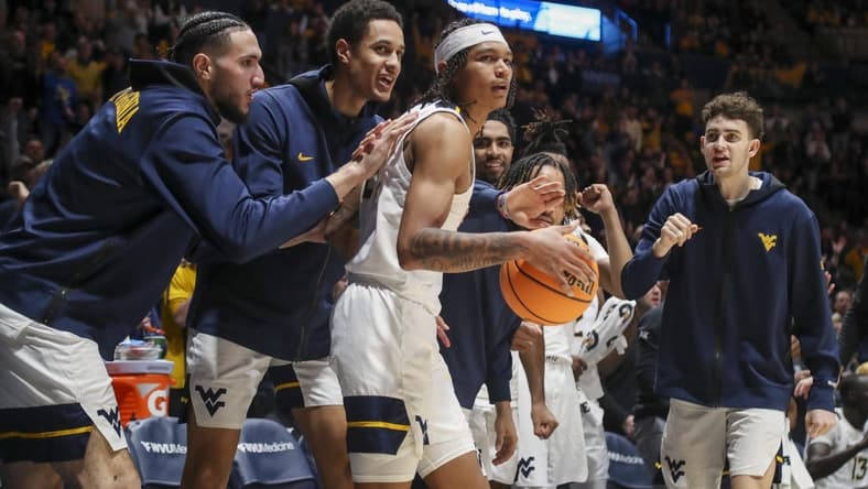 Jan 20, 2024; Morgantown, West Virginia, USA; West Virginia Mountaineers guard RaeQuan Battle (21) is greeted by teammates after a play during the second half against the Kansas Jayhawks at WVU Coliseum. Mandatory Credit: Ben Queen-USA TODAY Sports