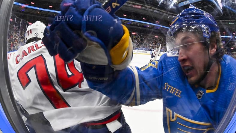 Jan 20, 2024; St. Louis, Missouri, USA; St. Louis Blues left wing Jake Neighbours (63) checks Washington Capitals defenseman John Carlson (74) during the second period at Enterprise Center. Mandatory Credit: Jeff Curry-USA TODAY Sports