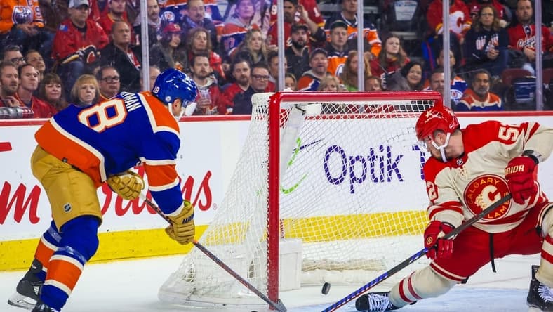 Jan 20, 2024; Calgary, Alberta, CAN; Edmonton Oilers left wing Zach Hyman (18) scores a goal as Calgary Flames defenseman MacKenzie Weegar (52) defends during the third period at Scotiabank Saddledome. Mandatory Credit: Sergei Belski-USA TODAY Sports