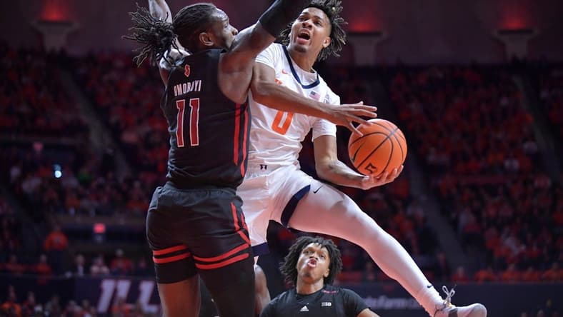 Jan 21, 2024; Champaign, Illinois, USA; Illinois Fighting Illini guard Terrence Shannon Jr. (0) drives to the basket as Rutgers Scarlet Knights center Clifford Omoruyi (11) defends during the first half at State Farm Center. Mandatory Credit: Ron Johnson-USA TODAY Sports