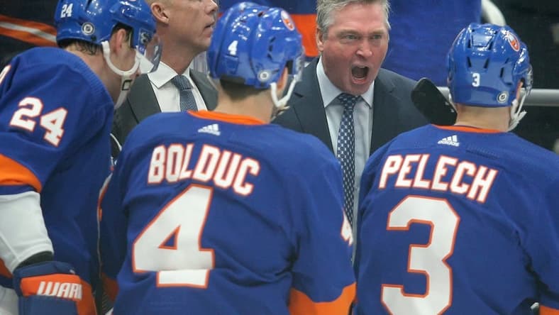Jan 21, 2024; Elmont, New York, USA; New York Islanders head coach Patrick Roy talks to defensemen Scott Mayfield (24) and Samuel Bolduc (4) and Adam Pelech (3) during the first period against the Dallas Stars at UBS Arena. Mandatory Credit: Brad Penner-USA TODAY Sports