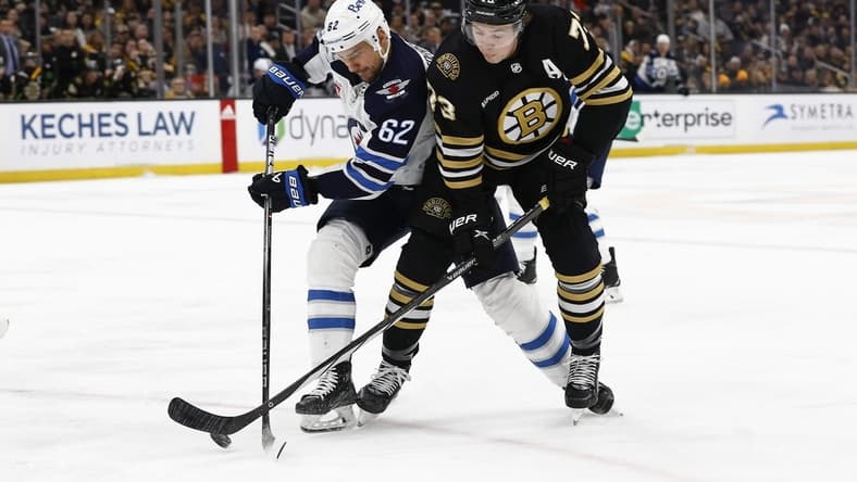 Jan 22, 2024; Boston, Massachusetts, USA; Boston Bruins defenseman Charlie McAvoy (73) and Winnipeg Jets right wing Nino Niederreiter (62) battle for a loose puck during the first period at TD Garden. Mandatory Credit: Winslow Townson-USA TODAY Sports