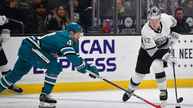 Jan 22, 2024; Los Angeles, California, USA; Los Angeles Kings defenseman Brandt Clarke (92) moves the puck against San Jose Sharks center Tomas Hertl (48) during the second period at Crypto.com Arena. Mandatory Credit: Gary A. Vasquez-USA TODAY Sports
