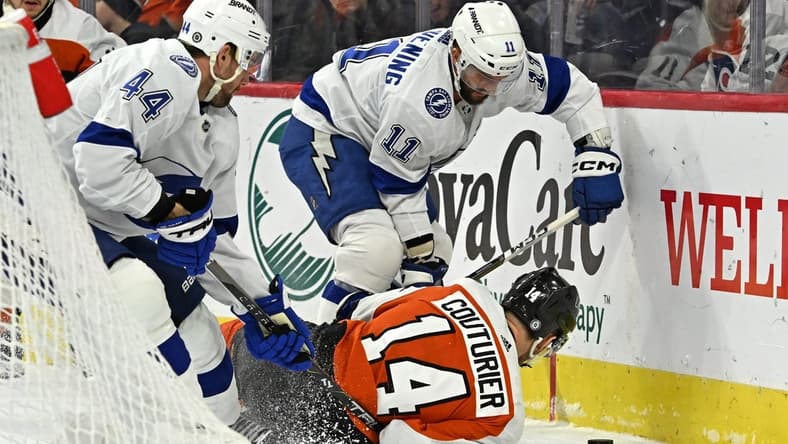 Jan 23, 2024; Philadelphia, Pennsylvania, USA; Philadelphia Flyers center Sean Couturier (14) battles for the puck with Tampa Bay Lightning center Luke Glendening (11) and defenseman Calvin de Haan (44) battle for the puck during the first period at Wells Fargo Center. Mandatory Credit: Eric Hartline-USA TODAY Sports