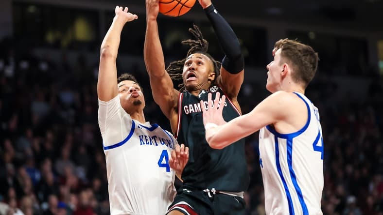 Jan 23, 2024; Columbia, South Carolina, USA; South Carolina Gamecocks guard Meechie Johnson (5) drives between Kentucky Wildcats forward Tre Mitchell (4) and forward Zvonimir Ivisic (44) in the first half at Colonial Life Arena. Mandatory Credit: Jeff Blake-USA TODAY Sports