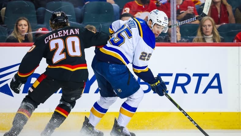 Jan 23, 2024; Calgary, Alberta, CAN; St. Louis Blues center Jordan Kyrou (25) controls the puck against Calgary Flames center Blake Coleman (20) during the first period at Scotiabank Saddledome. Mandatory Credit: Sergei Belski-USA TODAY Sports