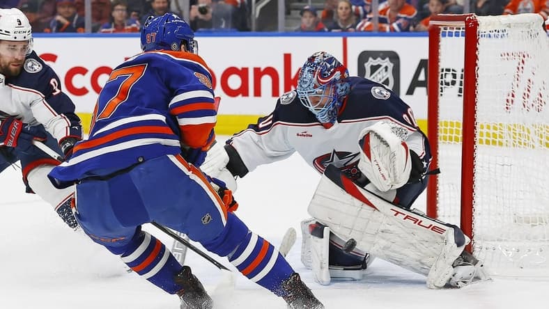 Jan 23, 2024; Edmonton, Alberta, CAN; Columbus Blue Jackets goaltender Elvis Merzlikins (90) makes a save on  on Edmonton Oilers forward Connor McDavid (97) during the first period at Rogers Place. Mandatory Credit: Perry Nelson-USA TODAY Sports