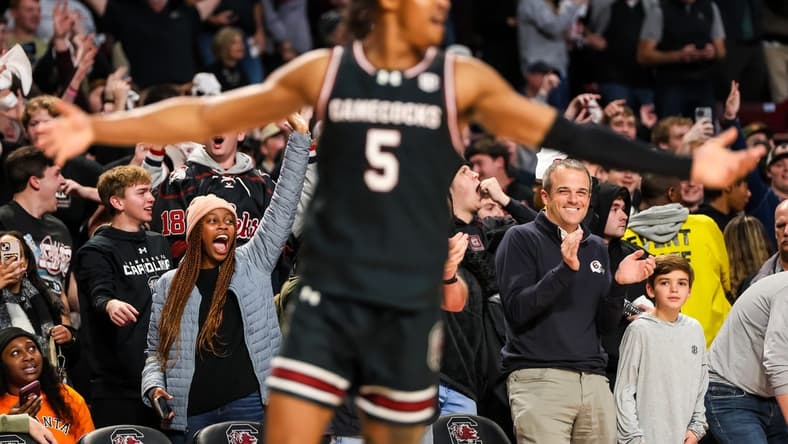 Jan 23, 2024; Columbia, South Carolina, USA; South Carolina Gamecocks head football coach Shane Beamer, bottom right, celebrates a three point basket by guard Meechie Johnson (5), foreground, against the Kentucky Wildcats in the second half at Colonial Life Arena. Mandatory Credit: Jeff Blake-USA TODAY Sports