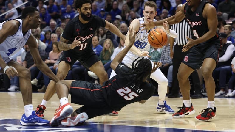 Jan 23, 2024; Provo, Utah, USA; Houston Cougars forward Joseph Tugler (25) passes the ball to guard L.J. Cryer (4) defended by Brigham Young Cougars guard Spencer Johnson (20) during the second half at Marriott Center. Mandatory Credit: Rob Gray-USA TODAY Sports
