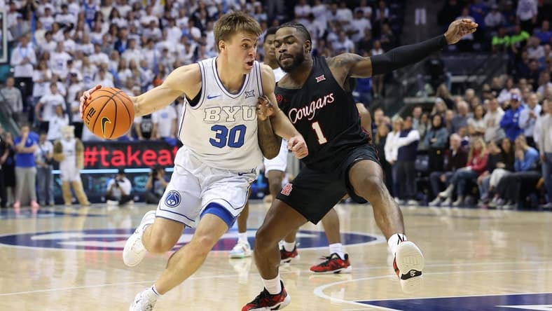 Jan 23, 2024; Provo, Utah, USA; Brigham Young Cougars guard Dallin Hall (30) drives the ball against Houston Cougars guard Jamal Shead (1) during the second half at Marriott Center. Mandatory Credit: Rob Gray-USA TODAY Sports
