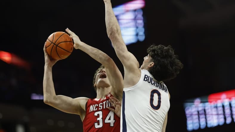 Jan 24, 2024; Charlottesville, Virginia, USA; North Carolina State Wolfpack forward Ben Middlebrooks (34) shoots the ball as Virginia Cavaliers forward Blake Buchanan (0) defends in the first half at John Paul Jones Arena. Mandatory Credit: Geoff Burke-USA TODAY Sports