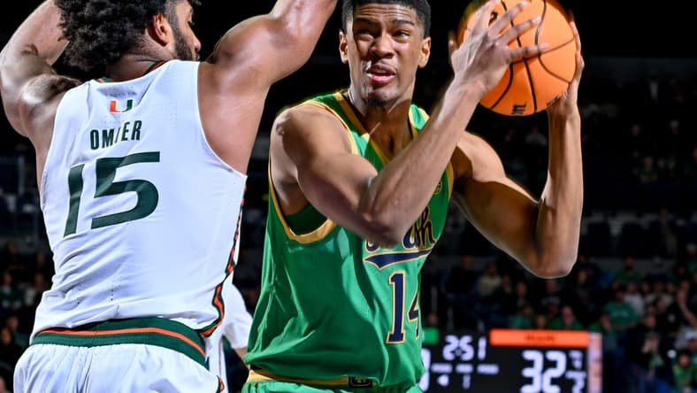 Jan 24, 2024; South Bend, Indiana, USA; Notre Dame Fighting Irish forward Kebba Njie (14) looks to shoot as Miami Hurricanes forward Norchad Omier (15) defends in the first half at the Purcell Pavilion. Mandatory Credit: Matt Cashore-USA TODAY Sports