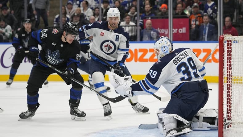 Jan 24, 2024; Toronto, Ontario, CAN; Winnipeg Jets goaltender Laurent Brossoit (39) makes a save as  Toronto Maple Leafs forward David Kampf (64) looks for a rebound during the first period at Scotiabank Arena. Mandatory Credit: John E. Sokolowski-USA TODAY Sports