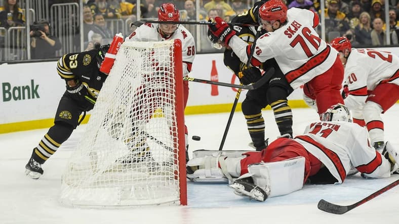 Jan 24, 2024; Boston, Massachusetts, USA; Boston Bruins right wing David Pastrnak (88) tries to bat the puck past Carolina Hurricanes goaltender Spencer Martin (41) while defenseman Brady Skjei (76) defends during the first period at TD Garden. Mandatory Credit: Bob DeChiara-USA TODAY Sports