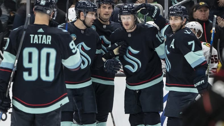 Jan 24, 2024; Seattle, Washington, USA; Seattle Kraken forward Jared McCann (19), second from right, is congratulated by forward Jordan Eberle (7), forward Tomas Tatar (90), defenseman Justin Schultz (4), second from left, and defenseman Brian Dumoulin (8) after scoring a goal against the Chicago Blackhawks during the first period at Climate Pledge Arena. Mandatory Credit: Stephen Brashear-USA TODAY Sports
