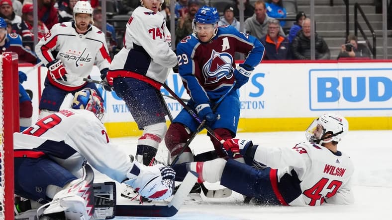 Jan 24, 2024; Denver, Colorado, USA; Colorado Avalanche center Nathan MacKinnon (29) shoots on Washington Capitals defenseman John Carlson (74) and goaltender Charlie Lindgren (79) and right wing Tom Wilson (43) in the second period at Ball Arena. Mandatory Credit: Ron Chenoy-USA TODAY Sports