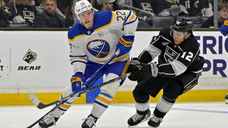 Jan 24, 2024; Los Angeles, California, USA; Buffalo Sabres right wing Jack Quinn (22) handles the puck as he is defended by Los Angeles Kings left wing Trevor Moore (12) in the second period at Crypto.com Arena. Mandatory Credit: Jayne Kamin-Oncea-USA TODAY Sports