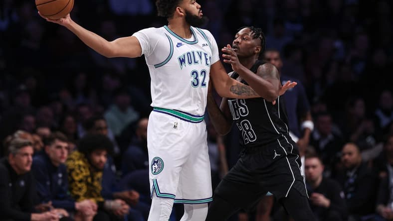 Jan 25, 2024; Brooklyn, New York, USA; Minnesota Timberwolves center Karl-Anthony Towns (32) shields the ball from Brooklyn Nets forward Dorian Finney-Smith (28) during the first quarter at Barclays Center. Mandatory Credit: Vincent Carchietta-USA TODAY Sports