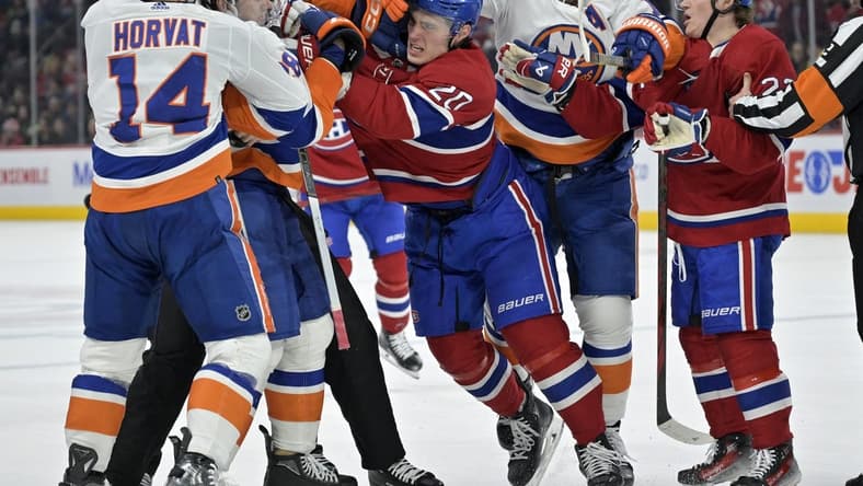Jan 25, 2024; Montreal, Quebec, CAN; Montreal Canadiens forward Juraj Slafkovsky (20) exchanges blows with New York Islanders defenseman Alexander Romanov (28) during the first period at the Bell Centre. Mandatory Credit: Eric Bolte-USA TODAY Sports