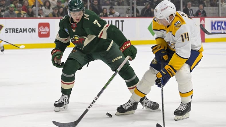 Jan 25, 2024; Saint Paul, Minnesota, USA; Minnesota Wild defenseman Brock Faber (7) poke-checks the puck away from Nashville Predators forward Gustav Nyquist (14) during the first period at Xcel Energy Center. Mandatory Credit: Nick Wosika-USA TODAY Sports