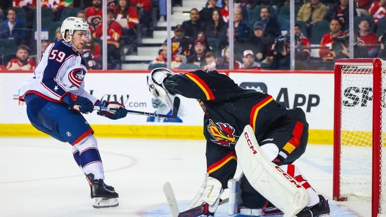 Jan 25, 2024; Calgary, Alberta, CAN; Calgary Flames goaltender Jacob Markstrom (25) makes a save against Columbus Blue Jackets right wing Yegor Chinakhov (59) during the second period at Scotiabank Saddledome. Mandatory Credit: Sergei Belski-USA TODAY Sports