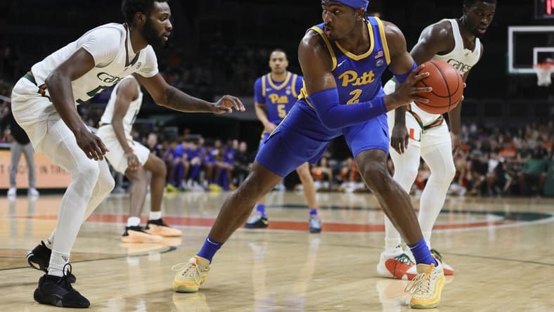 Jan 27, 2024; Coral Gables, Florida, USA; Pittsburgh Panthers forward Blake Hinson (2) protects the basketball from Miami Hurricanes guard Wooga Poplar (5) during the first half at Watsco Center. Mandatory Credit: Sam Navarro-USA TODAY Sports