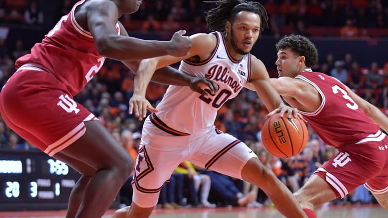 Jan 27, 2024; Champaign, Illinois, USA;  Illinois Fighting Illini forward Ty Rodgers (20) drives the ball between Indiana Hoosiers forward Payton Sparks (24) and guard Anthony Leal (3) during the first half at State Farm Center. Mandatory Credit: Ron Johnson-USA TODAY Sports