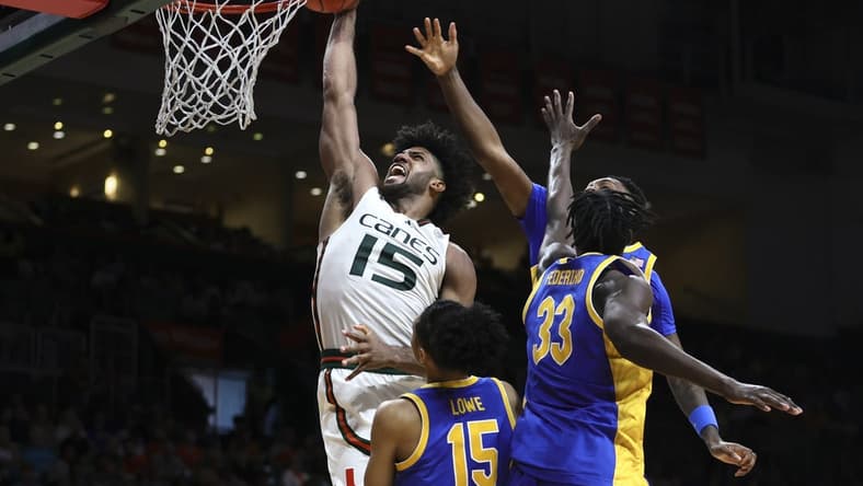 Jan 27, 2024; Coral Gables, Florida, USA; Miami Hurricanes forward Norchad Omier (15) dunks the basketball against Pittsburgh Panthers guard Jaland Lowe (15), center Federiko Federiko (33) and forward Zack Austin (55) during the second half at Watsco Center. Mandatory Credit: Sam Navarro-USA TODAY Sports