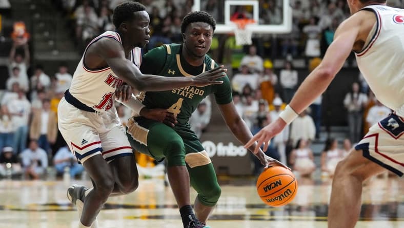 Jan 27, 2024; Laramie, Wyoming, USA; Colorado State Rams forward Isaiah Stevens (4) controls the ball against Wyoming Cowboys guard Akuel Kot (13) during the first half at Arena-Auditorium. Mandatory Credit: Troy Babbitt-USA TODAY Sports