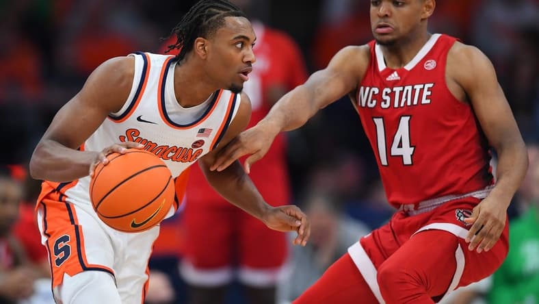Jan 27, 2024; Syracuse, New York, USA; Syracuse Orange guard JJ Starling (2) drives to the basket as North Carolina State Wolfpack guard Casey Morsell (14) defends during the first half at the JMA Wireless Dome. Mandatory Credit: Rich Barnes-USA TODAY Sports