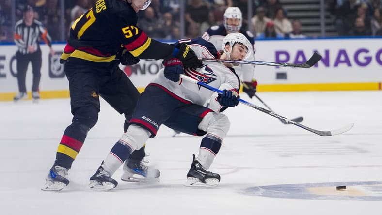 Jan 27, 2024; Vancouver, British Columbia, CAN; Vancouver Canucks defenseman Tyler Myers (57) checks Columbus Blue Jackets forward Adam Fantilli (11) in the third period at Rogers Arena. Canucks won 5-4 in overtime. Mandatory Credit: Bob Frid-USA TODAY Sports