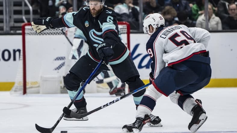 Jan 28, 2024; Seattle, Washington, USA; Seattle Kraken defenseman Adam Larsson (6) attempts to knock the puck away from Columbus Blue Jackets forward Yegor Chinakhov (59) during the second period at Climate Pledge Arena. Mandatory Credit: Stephen Brashear-USA TODAY Sports