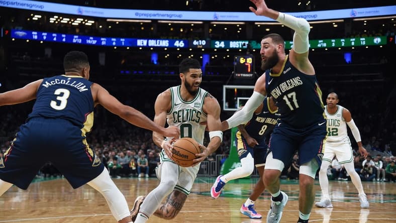 Jan 29, 2024; Boston, Massachusetts, USA; Boston Celtics forward Jayson Tatum (0) moves to the basket while New Orleans Pelicans guard CJ McCollum (3) and center Jonas Valanciunas (17) defend during the first half at TD Garden. Mandatory Credit: Bob DeChiara-USA TODAY Sports