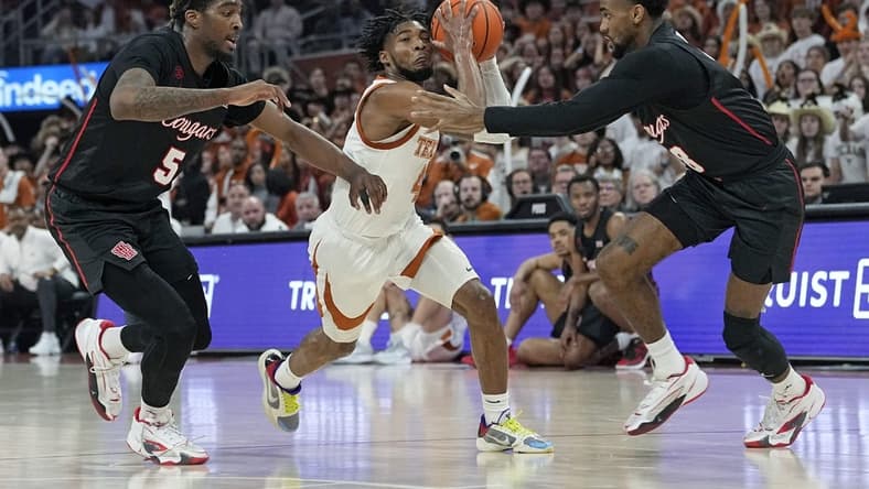 Jan 29, 2024; Austin, Texas, USA; Texas Longhorns guard Tyrese Hunter (4) drives to the basket between Houston Cougars forward Ja'Vier Francis (5) and guard Mylik Wilson (8) during the first half at Moody Center. Mandatory Credit: Scott Wachter-USA TODAY Sports