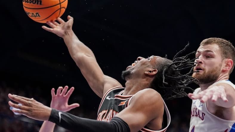 Jan 30, 2024; Lawrence, Kansas, USA; Oklahoma State Cowboys guard Jarius Hicklen (4) shoots as Kansas Jayhawks center Hunter Dickinson (1) defends during the first half at Allen Fieldhouse. Mandatory Credit: Denny Medley-USA TODAY Sports