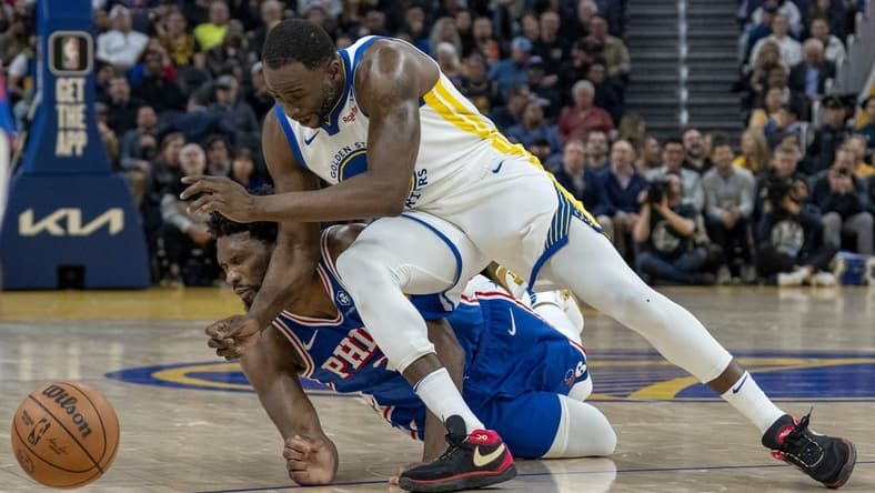 Jan 30, 2024; San Francisco, California, USA; Philadelphia 76ers center Joel Embiid (21) is called for an offensive foul against Golden State Warriors forward Draymond Green (23) during the second quarter at Chase Center. Mandatory Credit: Neville E. Guard-USA TODAY Sports