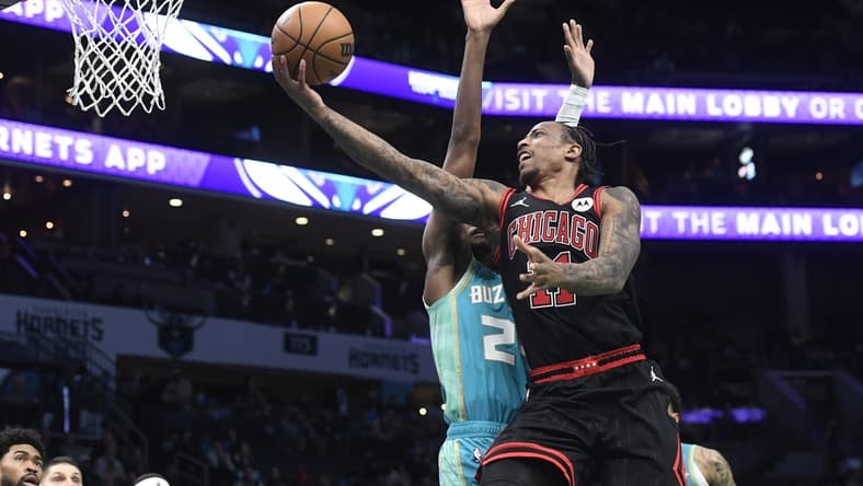 Jan 31, 2024; Charlotte, North Carolina, USA; Chicago Bulls guard DeMar DeRozan (11) drives in for a lay-up past Charlotte Hornets forward guard Brandon Miller (24) during the second half at the Spectrum Center. Mandatory Credit: Sam Sharpe-USA TODAY Sports