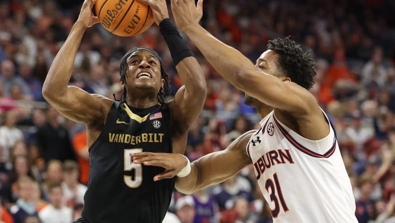 Jan 31, 2024; Auburn, Alabama, USA; Vanderbilt Commodores guard Ezra Manjon (5) takes a shot over Auburn Tigers guard Chaney Johnson (31) during the first half at Neville Arena. Mandatory Credit: John Reed-USA TODAY Sports