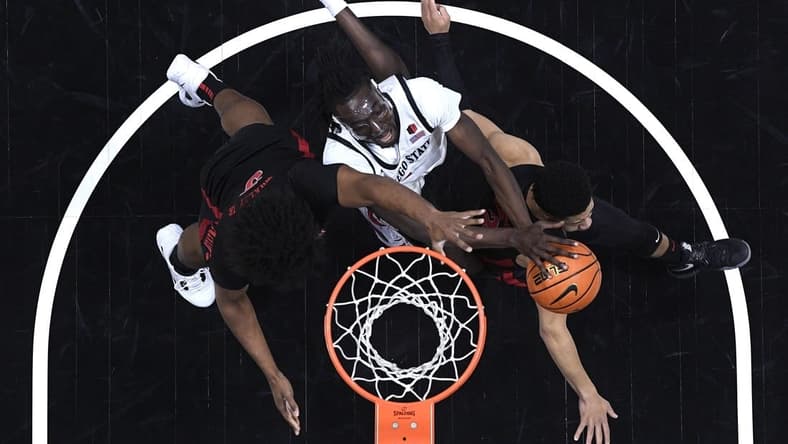 Jan 6, 2024; San Diego, California, USA; San Diego State Aztecs forward Jay Pal (center) goes to the basket defended by UNLV Rebels forward Rob Whaley Jr. (5) and guard Justin Webster (right) during the first half at Viejas Arena. Mandatory Credit: Orlando Ramirez-USA TODAY Sports