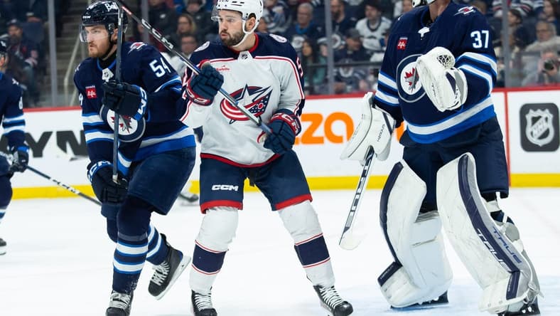 Jan 9, 2024; Winnipeg, Manitoba, CAN; Columbus Blue Jackets forward Emil Bemstrom (52) jostles for position with Winnipeg Jets defenseman Dylan Samberg (54) during the first period at Canada Life Centre. Mandatory Credit: Terrence Lee-USA TODAY Sports