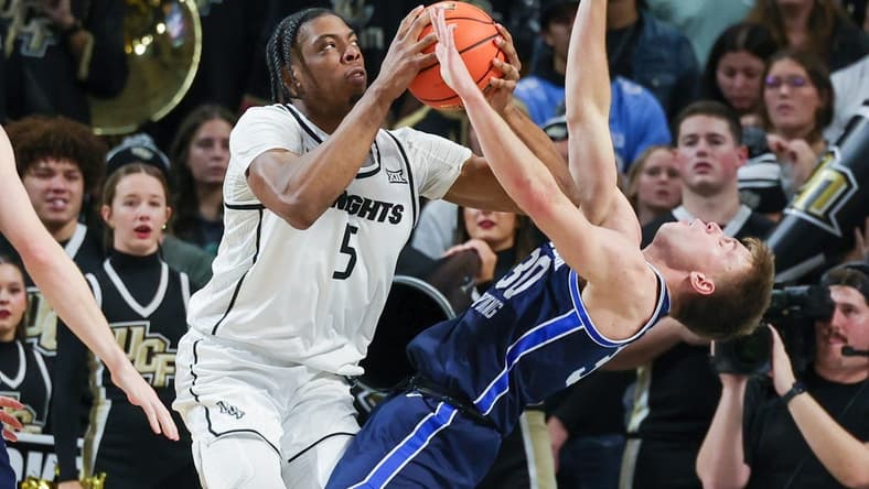 Jan 13, 2024; Orlando, Florida, USA; Brigham Young Cougars guard Dallin Hall (30) is fouled by UCF Knights forward Omar Payne (5) during the first period at Addition Financial Arena. Mandatory Credit: Mike Watters-USA TODAY Sports