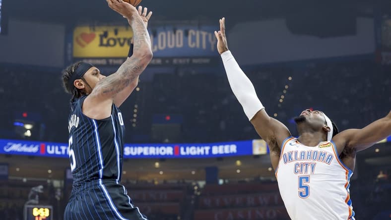 Jan 13, 2024; Oklahoma City, Oklahoma, USA; Orlando Magic forward Paolo Banchero (5) shoots as Oklahoma City Thunder guard Luguentz Dort (5) defends during the first quarter at Paycom Center. Mandatory Credit: Alonzo Adams-USA TODAY Sports